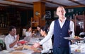 Friendly headwaiter with serving tray welcoming in restaurant Royalty Free Stock Photo