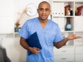 Friendly male doctor or nurse wearing blue scrubs uniform and stethoscope Royalty Free Stock Photo