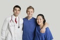 Portrait of friendly medical team standing over gray background