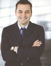 Portrait of a friendly middle aged businessman in a dark blue suit, standing with crossed arms together with a colleague Royalty Free Stock Photo