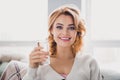 Portrait of friendly positive girl beaming smile sitting sofa hold glass fresh water bright house inside Royalty Free Stock Photo