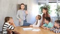 Portrait of friendly positive group of pupils with female teacher sitting in schoolroom