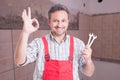 Portrait of friendly repairman doing ok gesture