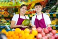 Portrait of friendly salespeople in fruit section of grocery store