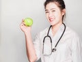 Portrait friendly, smiling, confident female doctor,holding green apple, health care professional, Happy young nurse standing fold Royalty Free Stock Photo