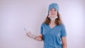 Portrait of a friendly smiling doctor woman or nurse in white medical uniform with a syringe, on white background with co Royalty Free Stock Photo