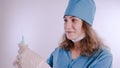 Portrait of a friendly smiling doctor woman or nurse in white medical uniform with a syringe, on white background with co Royalty Free Stock Photo