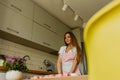 Portrait of friendly smiling female professional confectioner topping a cupcake with cream using a pastry bag. Looking Royalty Free Stock Photo