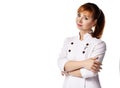 Young beautiful smiling red-haired woman doctor or nurse in white medical uniform standing with arms crossed over chest