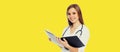 Portrait of friendly smiling young woman doctor with stethoscope and folder of documents on yellow background Royalty Free Stock Photo