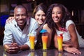 Portrait of friends enjoying while having cocktail drinks at bar counter Royalty Free Stock Photo