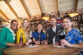Portrait of friends holding beer bottles and wine glasses on table Royalty Free Stock Photo