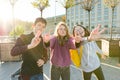 Portrait of friends teen boy and two girls smiling, making funny faces, showing victory sign in the street Royalty Free Stock Photo