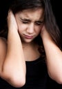 Portrait of a frightened girl on black background