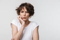 Portrait of frightened woman with short brown hair in basic t-shirt frowning and looking at camera Royalty Free Stock Photo