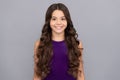 portrait of frizz child in purple dress. kid with curly hair. teen beauty hairstyle. Royalty Free Stock Photo