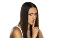 Portrait of a frowning woman with a finger in front of her lips Royalty Free Stock Photo