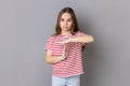 Little girl wearing T-shirt showing time out gesture, looking at camera deadline with test in school Royalty Free Stock Photo