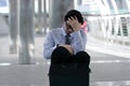 Portrait of frustrated stressed young Asian man sitting on the floor of sidewalk office and feeling tired with job Royalty Free Stock Photo