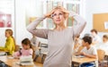 Portrait of frustrated tired teacher against the background of school class