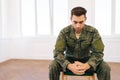 Portrait of frustrated veteran male in camouflage uniform sitting in circle during PTSD group therapy session looking Royalty Free Stock Photo