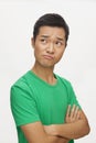 Portrait of frustrated young man, arms crossed, studio shot Royalty Free Stock Photo