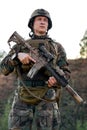 portrait of fully equipped, young soldier in camouflage uniform ready to fire Royalty Free Stock Photo