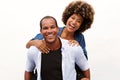 Fun couple laughing in embrace by white wall Royalty Free Stock Photo