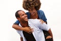 Fun couple smiling in embrace by white wall Royalty Free Stock Photo