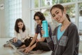Portrait fun students showing bottled water sit down working in groups Royalty Free Stock Photo