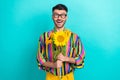 Portrait of funky cheerful man arms hold bunch sunflowers beaming smile isolated on emerald color background
