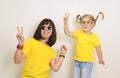 Portrait funky crazy hipsters girs in funny eyeglasses and yellow t-shirts laugh open mouth having fun together