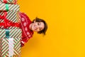 Portrait of funky nice woman with stylish hair wear sweater hide in presents under christmas tree isolated on yellow Royalty Free Stock Photo