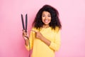 Portrait of funky positive black lady hold hair straightener point index finger enjoy good perfect salon treatment show