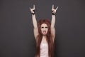 Portrait of funky young woman sticking out tongue and making rebellious gestures over black background Royalty Free Stock Photo