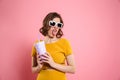 Portrait of a funnny girl in sunglasses holding cup