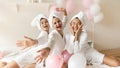 Portrait funny Asian bride with bridesmaids sitting on bed