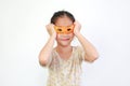Portrait of funny asian little girl play wearing glasses made from Orange peel on white background isolated Royalty Free Stock Photo