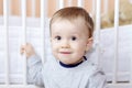 Portrait of funny baby against white bed Royalty Free Stock Photo