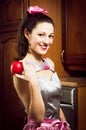 Portrait of funny beautiful pinup woman brunette girl happy smiling and holds red juicy apple & looking at camera portrait Royalty Free Stock Photo