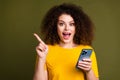 Portrait of funny blogger young woman with smartphone amazing discounts point finger mockup estore isolated on khaki Royalty Free Stock Photo