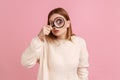 Funny woman standing, holding magnifying glass and looking at camera with big zoom eye. Royalty Free Stock Photo