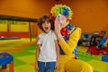 Portrait funny boy child and clown animator at indoor playground