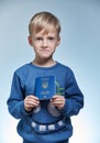Portrait funny boy7 years old with a children`s international passport of Ukraine