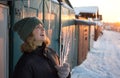 Portrait of a funny teenage girl who enthusiastically collects large transparent icicles on a cold sunny winter day Royalty Free Stock Photo