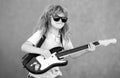 Portrait of a funny child with glasses practicing a song during a guitar lesson on street. Music concept, kids music Royalty Free Stock Photo