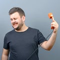 Portrait of funny chubby man in shock while talking on phone having unpleasant conversation against gray background Royalty Free Stock Photo