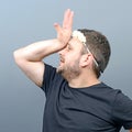 Portrait of funny chubby man wearing flower wreath on head and behaving feminine against gray background Royalty Free Stock Photo