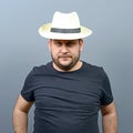 Portrait of funny chubby man wearing straw hat