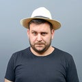 Portrait of funny chubby man wearing straw hat